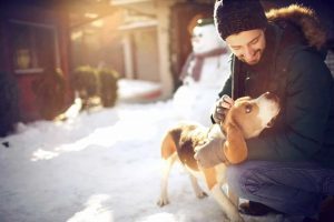 Man petting dog on a winter day